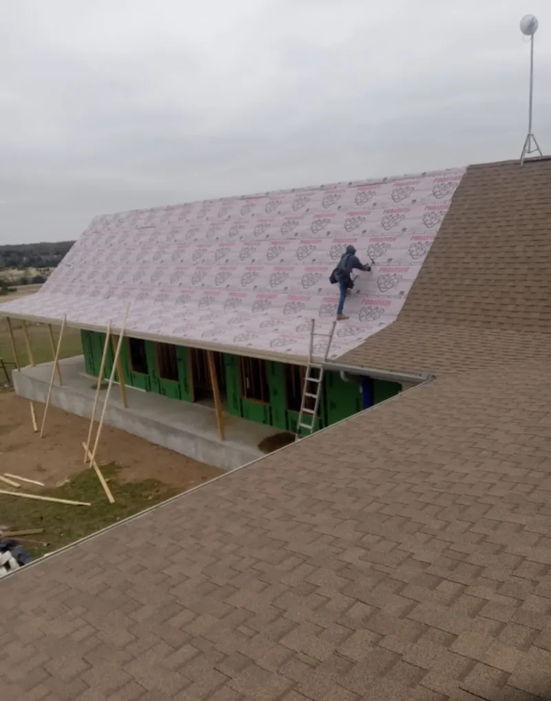Worker preparing underlayment for a metal roof installation in Mount Vernon